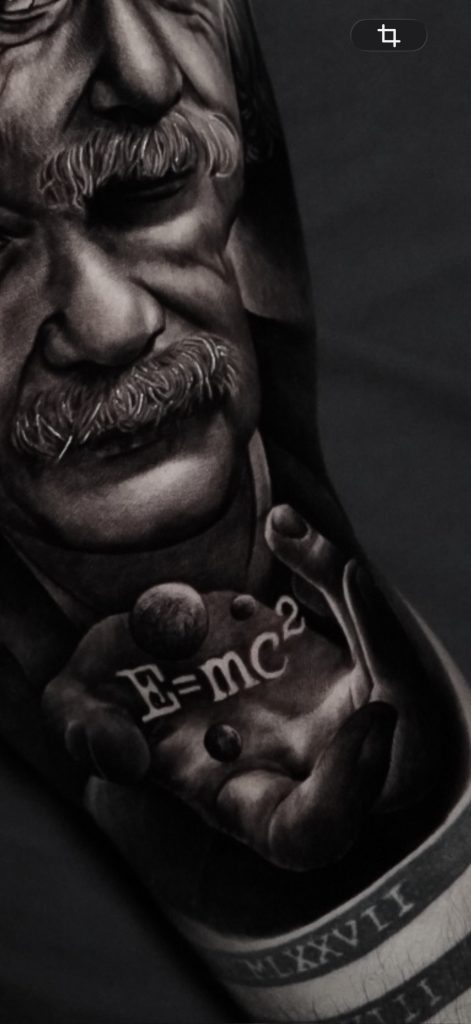 Detalle inferior del tatuaje de Albert Einstein con la mano y la fórmula E=mc².