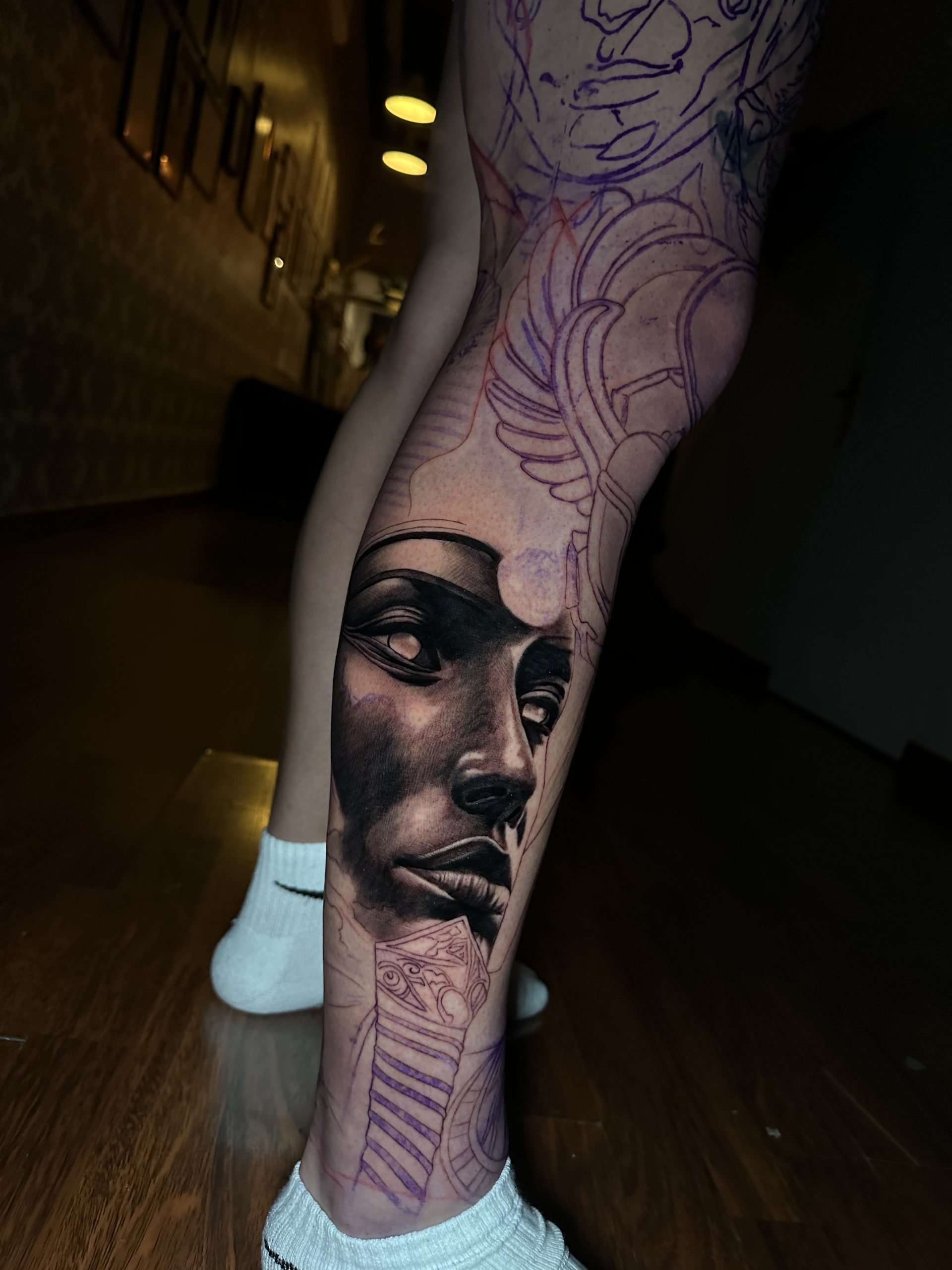 Proceso intermedio del tatuaje Legado de los Dioses, con una parte de la pierna terminada y otras zonas todavía en desarrollo.