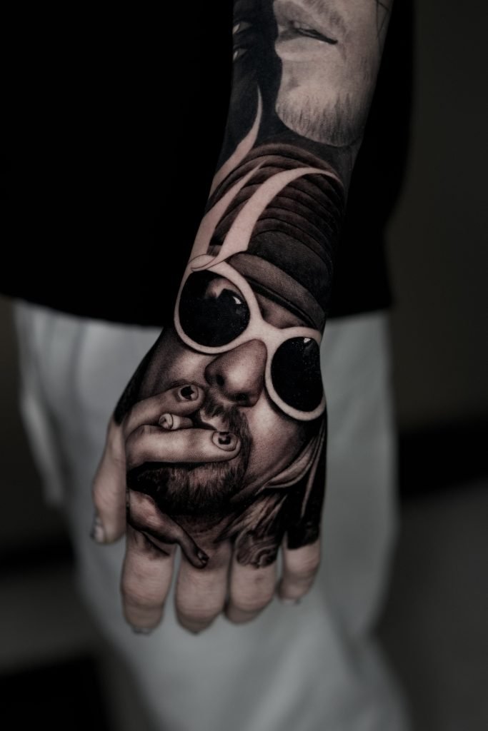 Retrato tatuado sobre la mano como continuación de la manga Voces que dejaron huella.